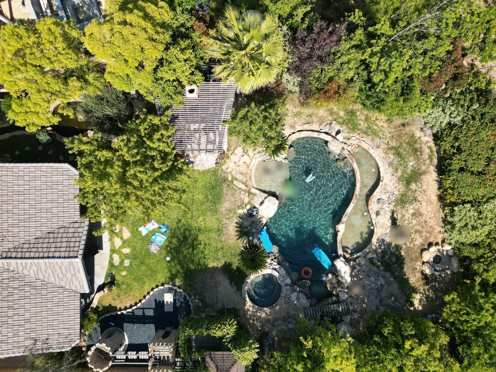 Overhead drone photo of the original lagoon pool, spa and lawn before the remodel