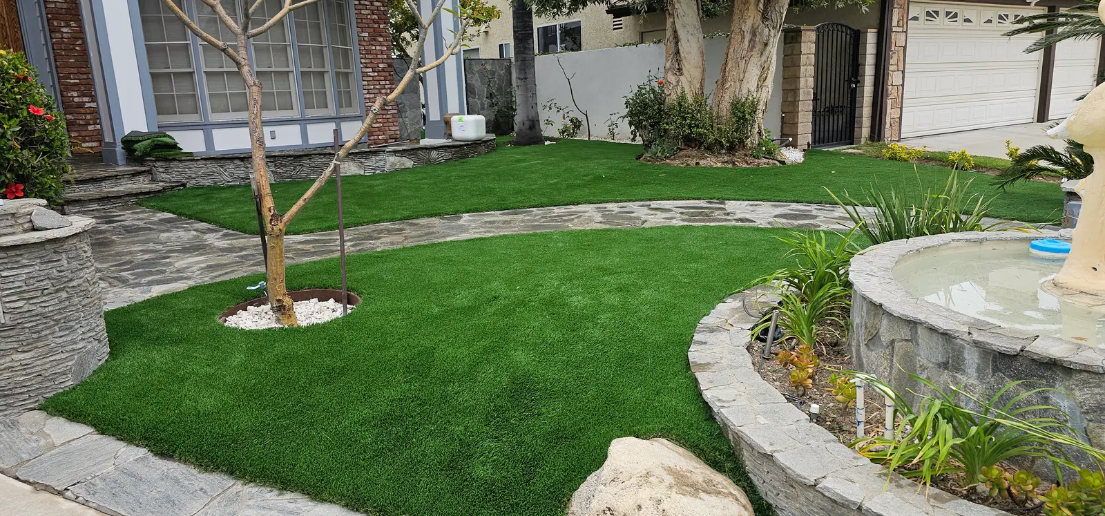 Artificial turf lawn with curved flagstone walks and planters